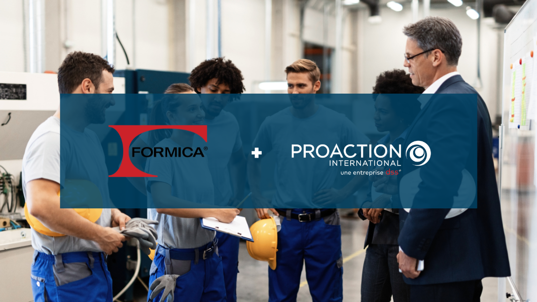 Équipe de travailleurs souriants, discutant avec deux managers, debout dans un atelier