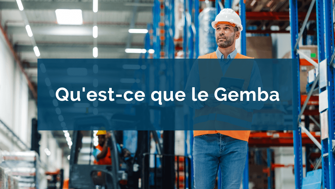 Travailleur portant un casque et une veste de sécurité, se promenant dans un entrepôt et observant au loin, une tablette à la main