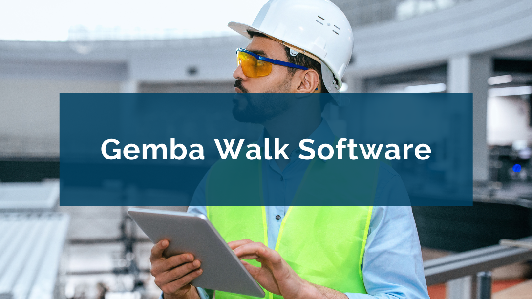 Manager wearing personal protective equipment, looking into the distance in an industrial environment, with a tablet in his hand