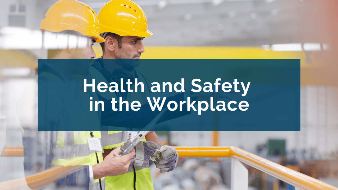 A manager and a worker wearing hard hats and safety vests, the manager pointing and looking into the distance in the factory