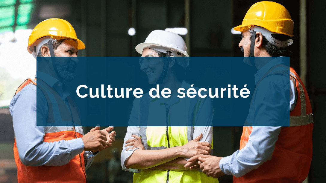 Trois collègues souriants, portant des vestes et casques de sécurité, discutant sur un chantier